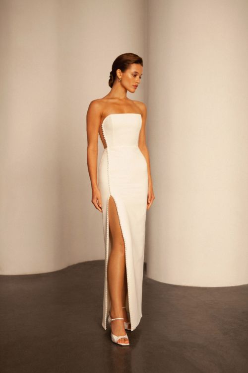 minimalist wedding dress, side cut out wedding dress, strapless wedding dress, corset wedding dress, sheath wedding dress, crepe wedding dress, modern wedding dress, slit wedding dress, fitted wedding dress, button front wedding dress, straight neckline wedding dress, bridal gown, simple wedding dress