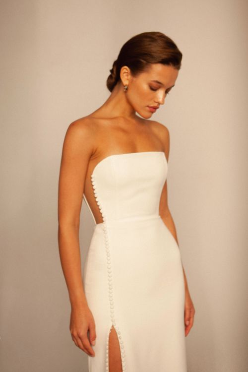 minimalist wedding dress, side cut out wedding dress, strapless wedding dress, corset wedding dress, sheath wedding dress, crepe wedding dress, modern wedding dress, slit wedding dress, fitted wedding dress, button front wedding dress, straight neckline wedding dress, bridal gown, simple wedding dress