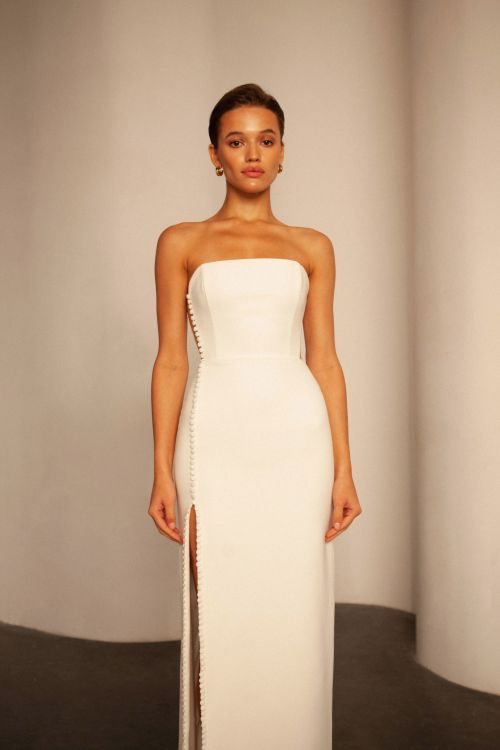 minimalist wedding dress, side cut out wedding dress, strapless wedding dress, corset wedding dress, sheath wedding dress, crepe wedding dress, modern wedding dress, slit wedding dress, fitted wedding dress, button front wedding dress, straight neckline wedding dress, bridal gown, simple wedding dress